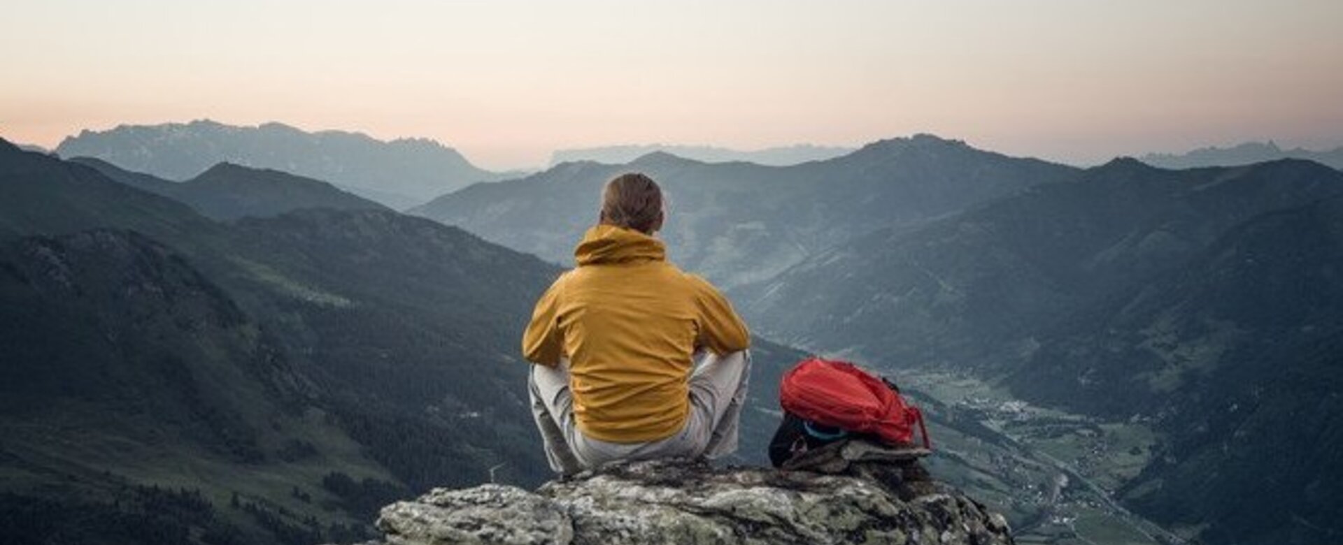A man sits on a rock and watches the sunset over the mountains | © Gasteinertal Tourismus GmbH - moodley