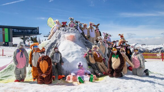 Group of skiers in Easter bunny costumes posing on snowy hill in sunny weather at ski resort area | © Shuttleberg