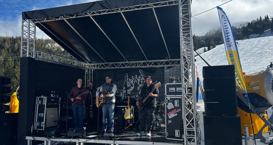 Four people stand on a small stage and a ski slope can be seen in the background  | © Hauser Kaibling