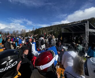 Viele Personen in Skiausrüctung stehen vor einer kleinen Bühne auf der Musiker spielen | © Hauser Kaibling