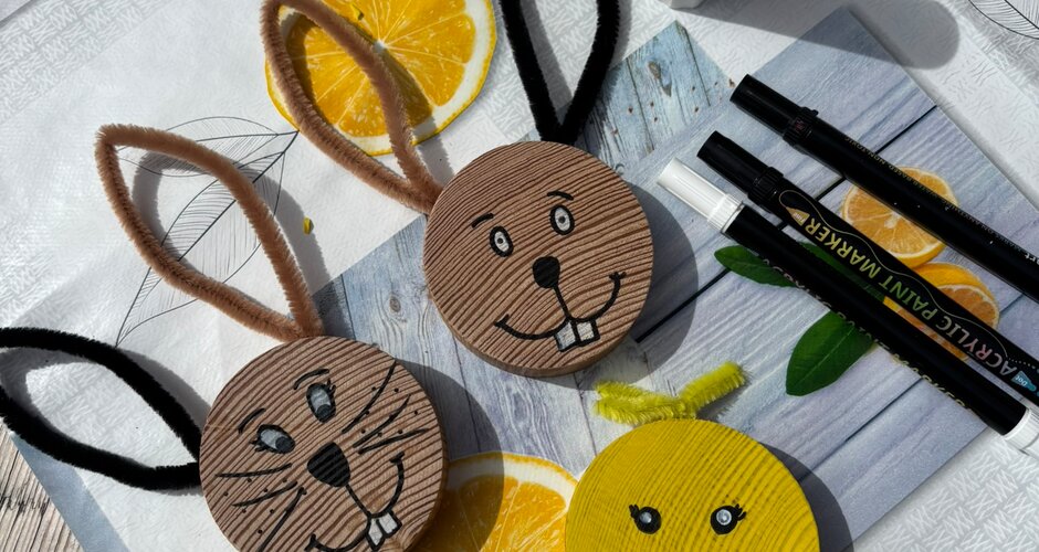 Handmade bunny and chick figures made of cardboard lie with pens and glue on a table at the Easter programme | © Planai