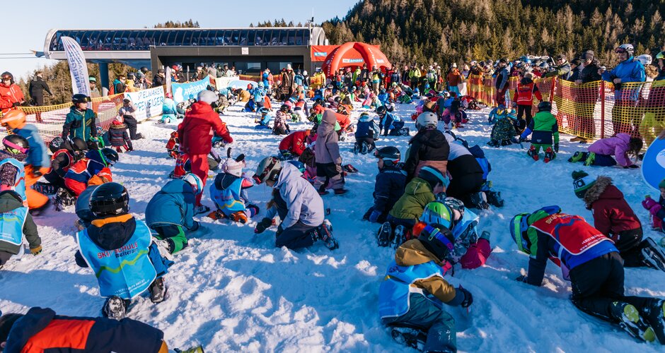 Numerous children kneel in the snow searching for treasures during an event at Reiteralm station | © Gerald Grünwald