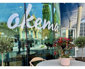 okema lettering on a glass front and a table with a flower | © Stefflbäck | okema