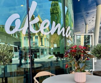 okema lettering on a glass front and a table with a flower | © Stefflbäck | okema