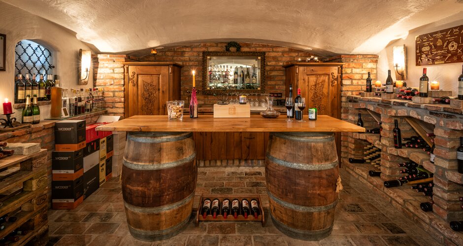 Wine cellar with wooden barrels, brick shelves, candles and wine bottles