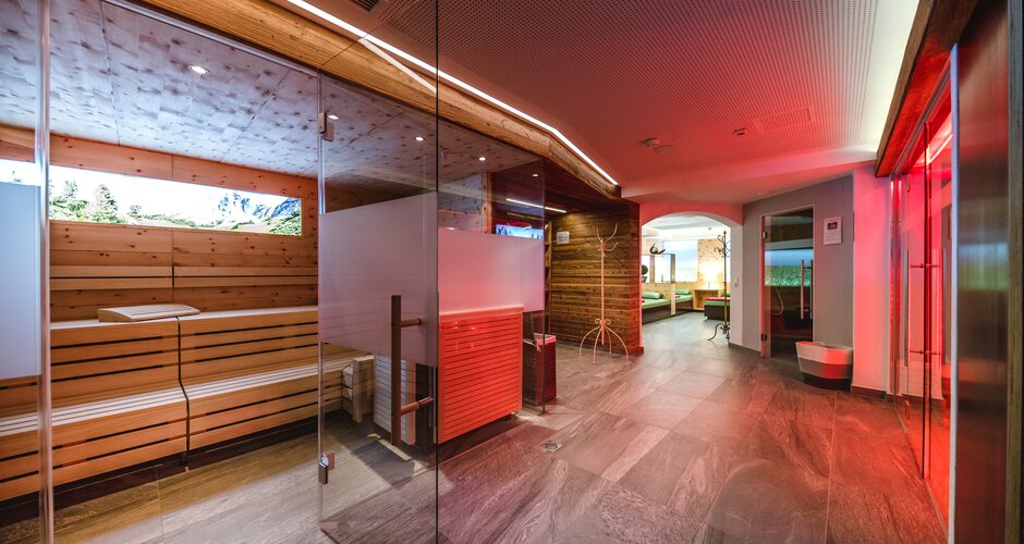 Modern sauna area with wooden sauna, glass front and cosy relaxation zone | © Nadja Nabli