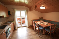 Kuchyň-obývací pokoj s jídelním koutem, kuchyňským koutem a balkonem