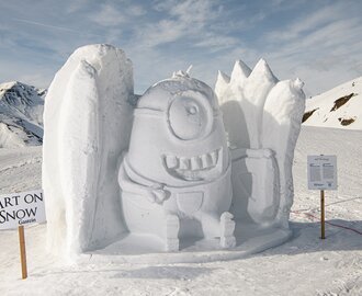 Large snow sculpture of a grinning Minion with details on a snowy plateau at Art on Snow Gastein.
