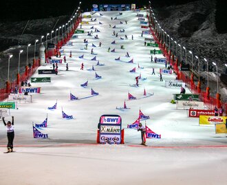 Floodlit parallel slalom course with snowboarders at the Gastein World Cup finishing at night. | © Stefan Lauterbach