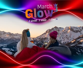 Two women with drinks sit facing snowy Alps at sunset, March Glow graphic overlay above