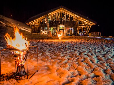 There are fire bowls in the snow in front of the TOM Almhütte. | © Edith Danzer
