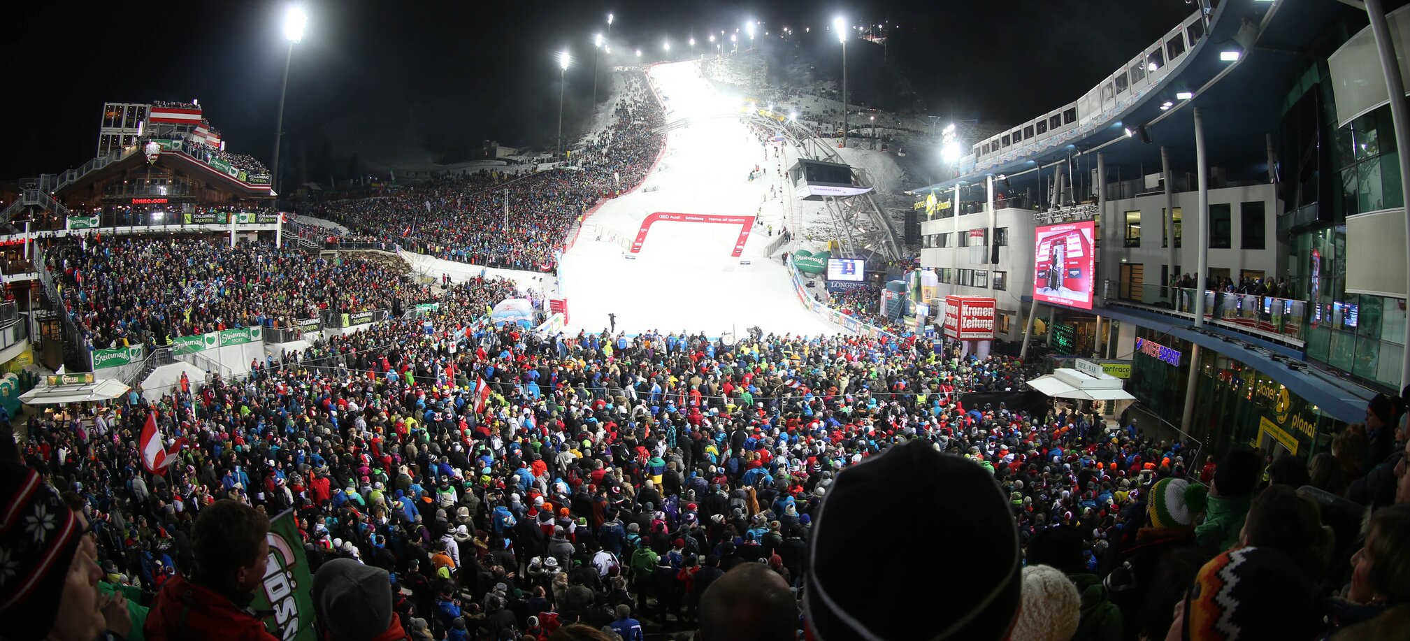 Crowd stands around the finish line of the men's slalom