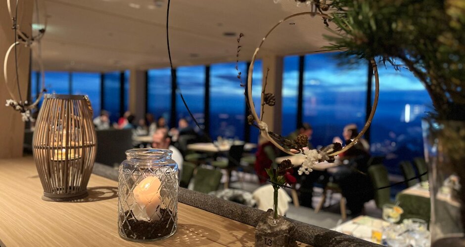Candle decoration in glass jar with evening view of Dachstein during festive Advent atmosphere | © Planai-Hochwurzen-Bahnen