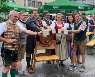 Beer tapping at Altsteirer Kirtag with traditional dress and mountains