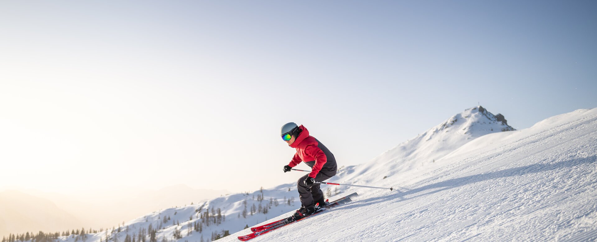 Ski Fahrer in schwarzer Skihose und schwarz-rote Skijacke fährt über frisch präperierte Piste | © Snow Space Salzburg