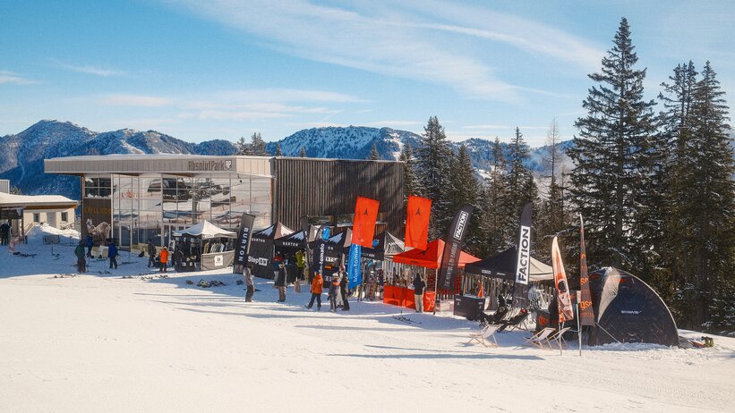 Test tents and brand booths with skis and snowboards in front of Absolut Park building at Shuttleberg | © Shuttleberg