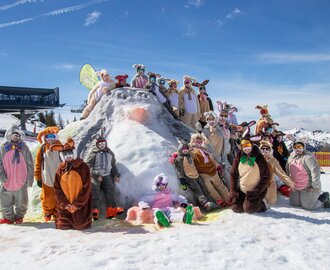 Group of skiers in Easter bunny costumes posing on snowy hill in sunny weather at ski resort area | © Shuttleberg