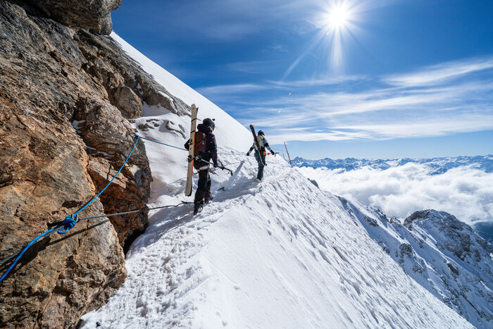 Two skiers with gear hike secured along a ridge to Edelgrieß freeride route | © Josh Absenger