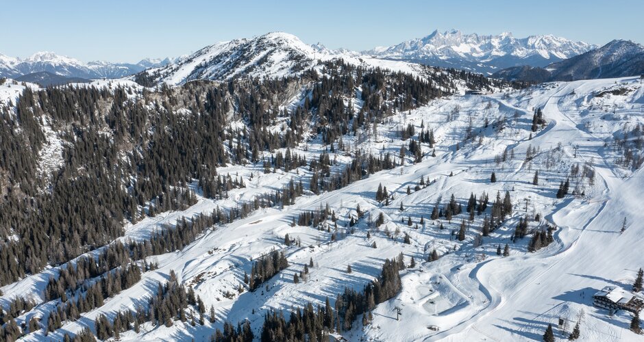 Aerial view of snowy Shuttleberg ski area with Funcross course and alpine mountain backdrop | © Shuttleberg