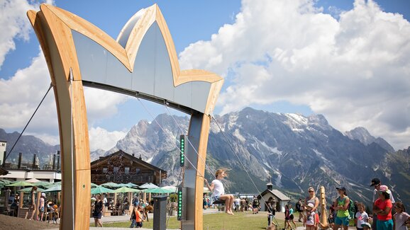 Waterfall swing with a scaffolding in the shape of a crown and lots of people around it | © Manu Lochner