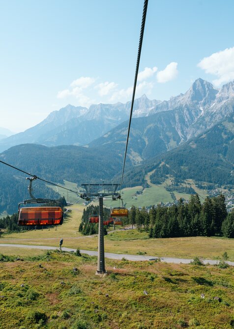 Black and orange chairlift descends into the valley | © Miriam Lottes