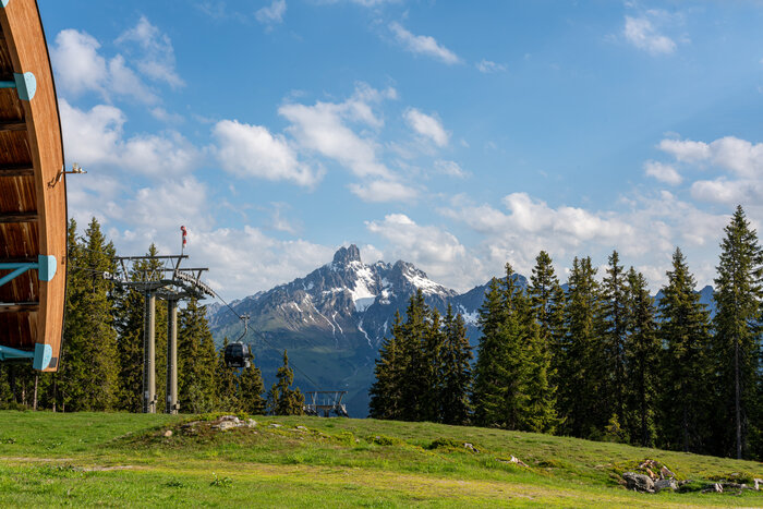 Papageno gondola above green meadow with Filzmoos' iconic twin peak Bischofsmütze | © Coen Weesjes