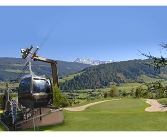 Birdie Jet gondola at Radstadt Golf Club, positioned near hole 12 green, with scenic view of forested hills and mountains. | © Golfclub Radstadt