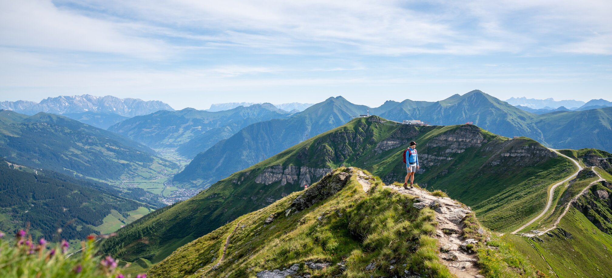Wanderer auf einem Gratweg am Stubnerkogel mit weitem Blick über das grüne Gasteinertal und die umliegenden Berggipfel | © Gasteinertal Tourismus GmbH, Christoph Oberschneider