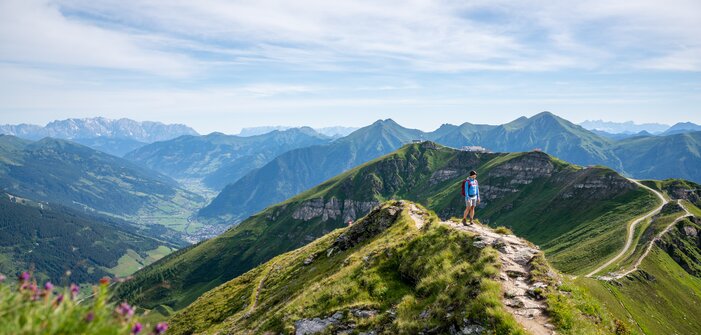 Hiker on a ridge trail at Stubnerkogel with a wide view over the green Gastein Valley and the surrounding mountain peaks | © Gasteinertal Tourismus GmbH, Christoph Oberschneider