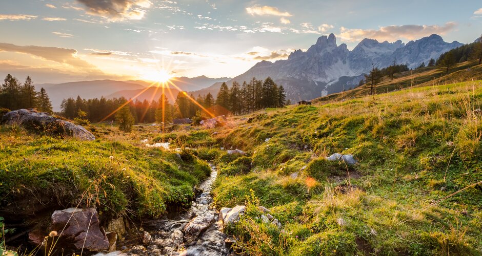 Sunrise over a bubbling mountain stream with green meadows and Bischofsmütze mountain in the background near Filzmoos | © CoenWeesjes | Filzmoos Tourismus