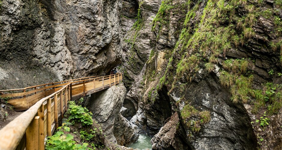 Wooden walkway along Liechtenstein Gorge above a narrow rocky ravine with stream and steep vegetated walls. | © Walter Oczlon