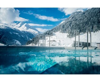 Swimming pool with mountainous snowy landscape in the background | © Max Steinbauer Photography