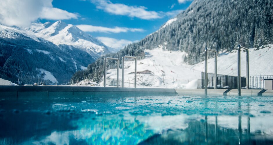 Swimming pool with mountainous snowy landscape in the background | © Max Steinbauer Photography