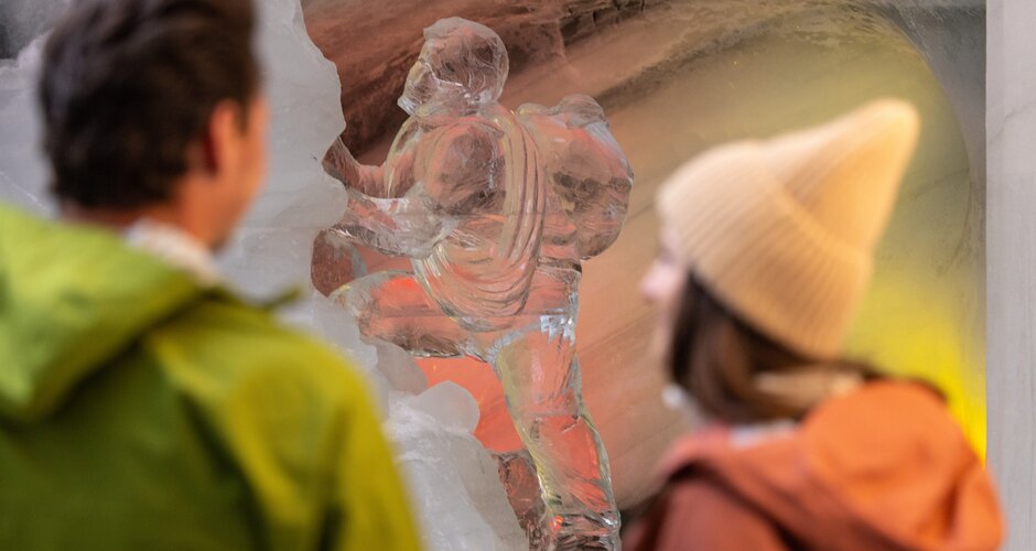 Two people looking at an ice sculpture of a climber in the Dachstein Ice Palace. | © Harald Steiner