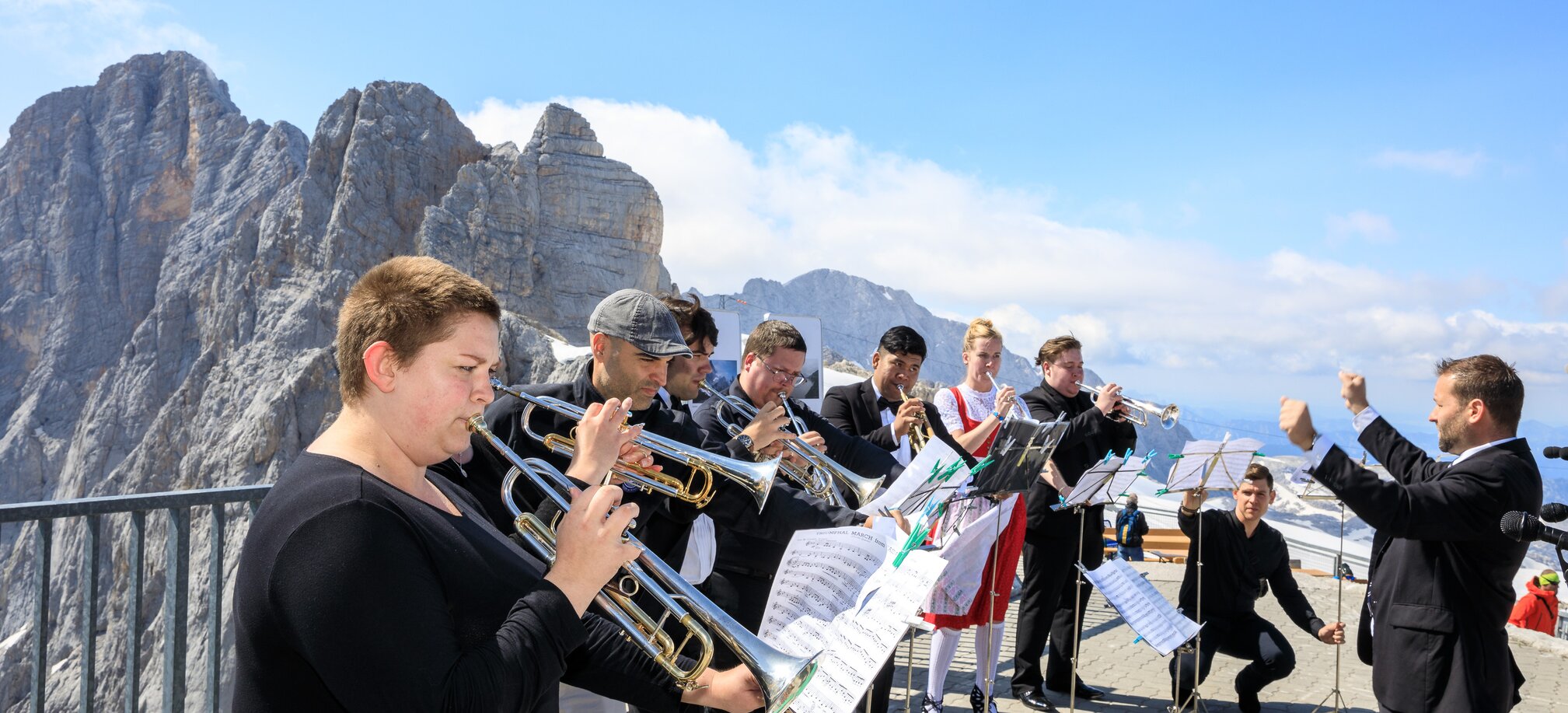 Brass band with conductor on the Dachstein Glacier with mountain backdrop. | © Martin Huber