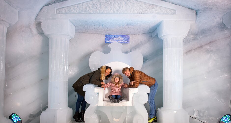 Family posing on an ice throne in front of ice walls at the Dachstein Ice Palace. | © Christoph Huber