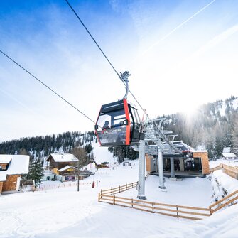 Red Galsterberg gondola above top station with snowy landscape. | © Josh Absenger