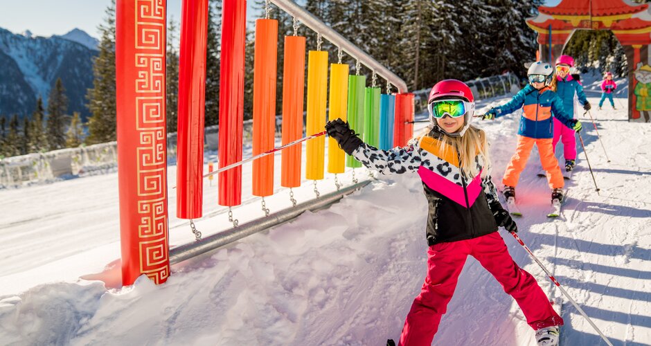 Skiing children at Hopsi Winter Children’s Land Planai with colourful snow course | © Christine Höflehner