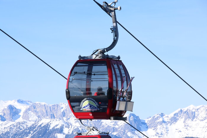 red gondola and snow-covered mountains in the background
