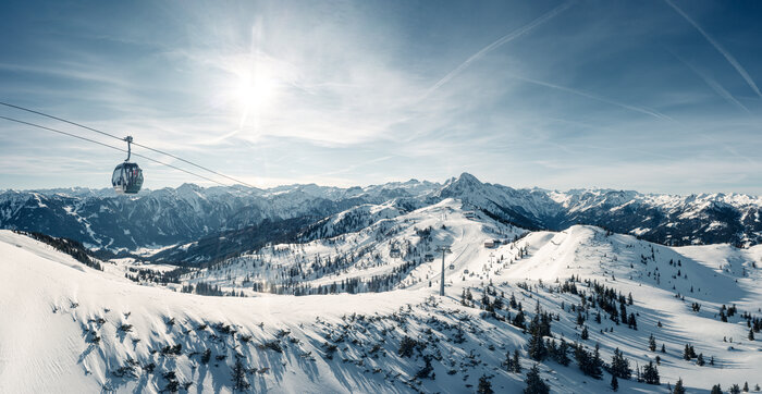 Picture of the cable car on the shuttle mountain as it crosses over the piste and the snowy slopes | © Markus Rohrbacher