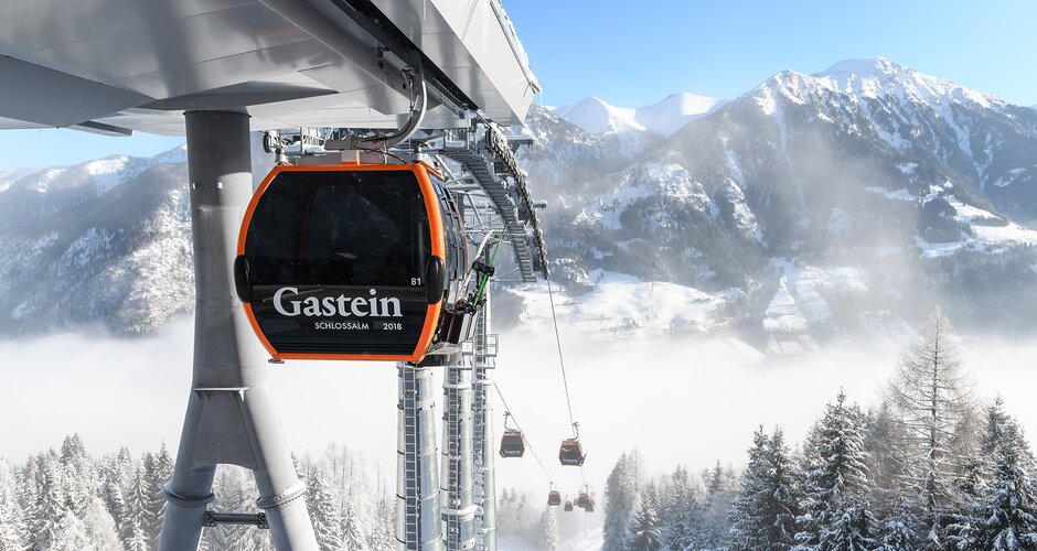Cable car ascends out of the fog and snow-capped mountains can be seen in the background | © Gasteiner Bergbahnen AG; Marktl Photography