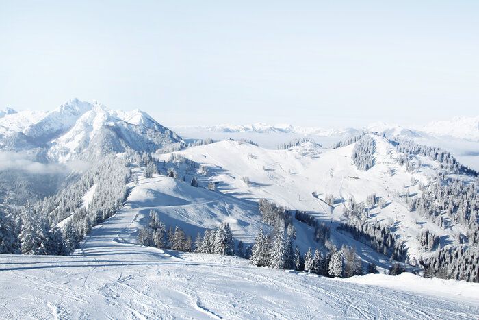 Snow-covered piste landscape with views of the surrounding snow-capped mountains and a bright blue sky | © Snow Space Salzburg