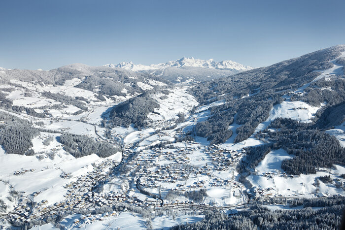 Aerial view of Wagrain, snowy valley with houses, trees and mountains | © Snow Space Salzburg