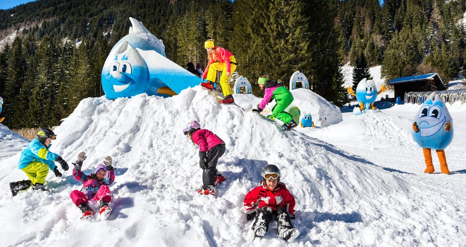 Kids playing on a snow hill with Gasti mascot at the kids park in Gastein | © Gasteiner-Bergbahnen AG