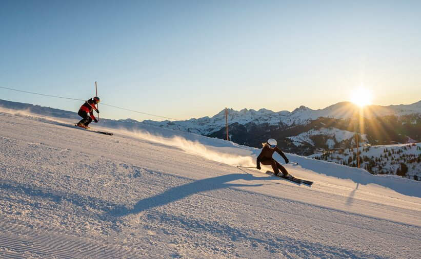 Two skiers carving on freshly groomed slope in Grossarltal at sunrise | © TVB Grossarltal / Lorenz Masser