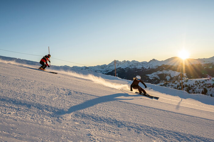 Two skiers carving on freshly groomed slope in Grossarltal at sunrise | © TVB Grossarltal / Lorenz Masser