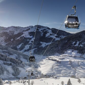 Sonnbergbahn gondolas move above snowy slopes near Maria Alm in winter sunshine | © www.felsch-foto.at