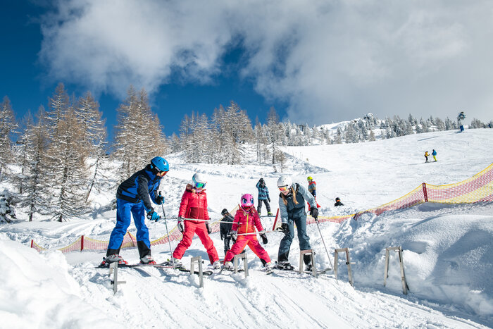Two adults and two kids at the starting gate of a race track on the Shuttleberg | © Salzburger Sportwelt